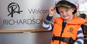 Young boy in Captains Yacht Cap about to board a Day Boat